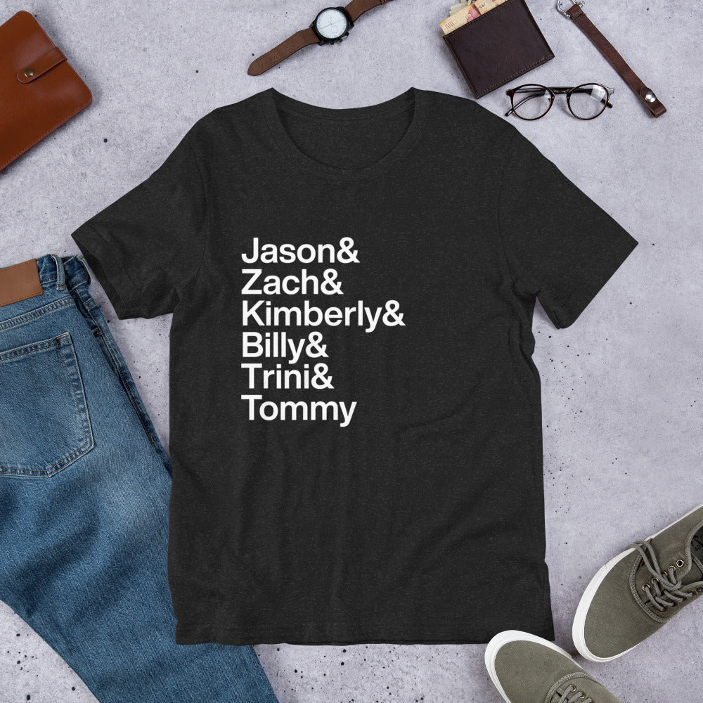 black t-shirt with white lettering reading Jason and Zach and Kimberly and Billy and Trini and Tommy on the ground amidst other apparel