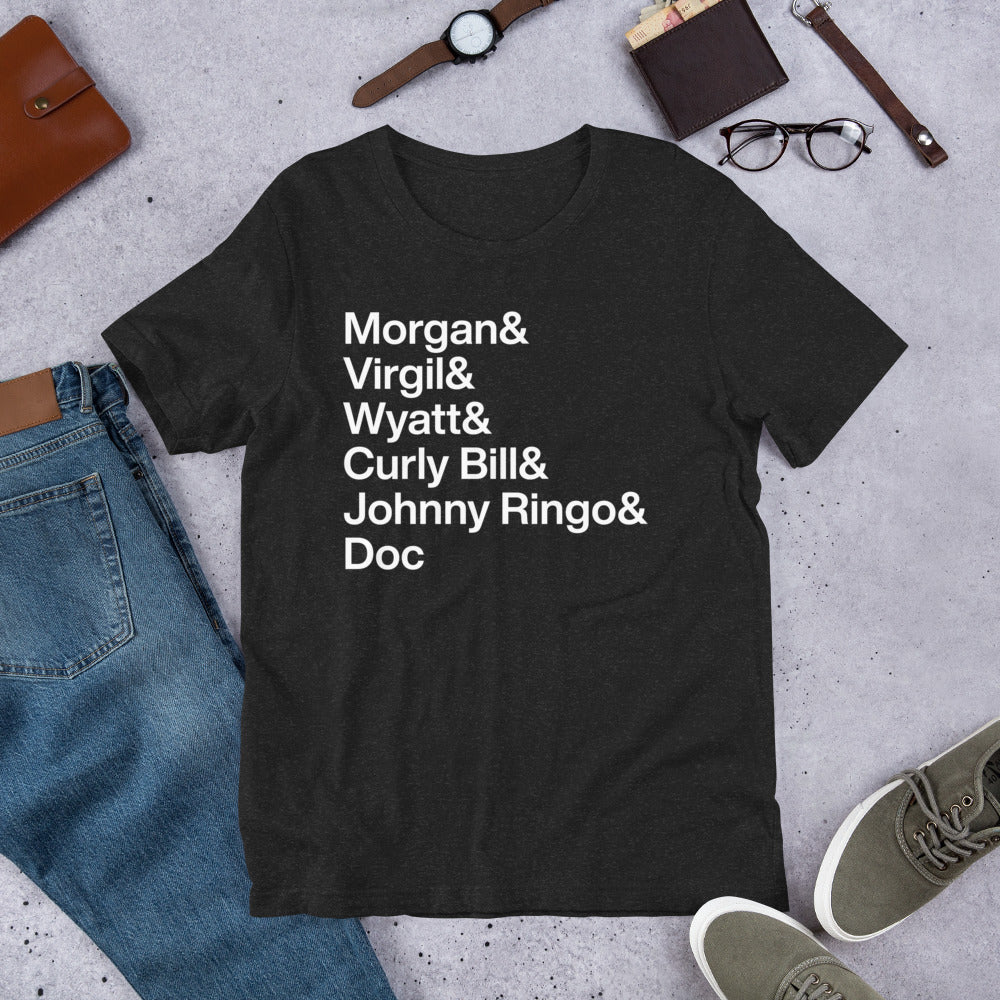 black t-shirt with white lettering reading Morgan and Virgil and Wyatt and Curly Bill and Johnny Ringo and Doc on the ground with other apparel
