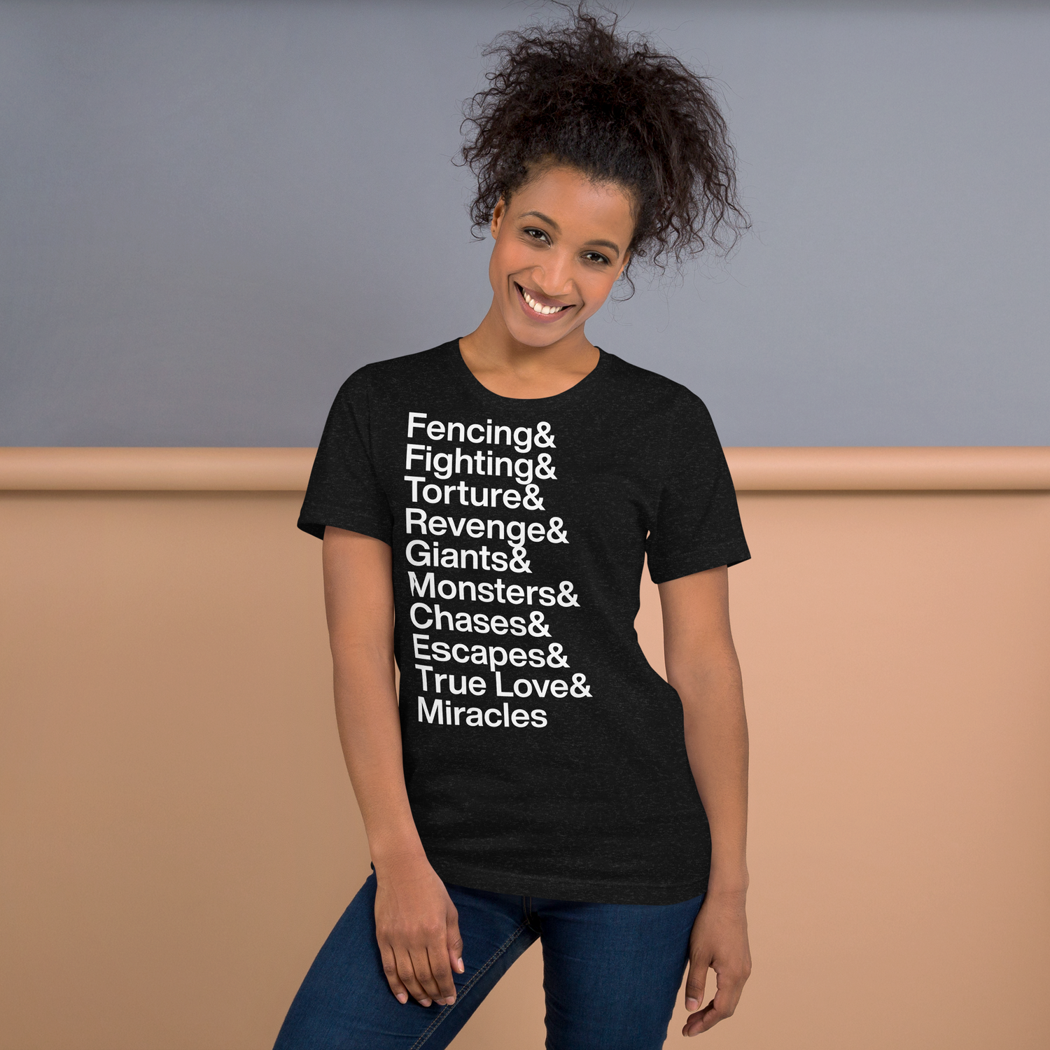 Young woman posing in a black t-shirt with white lettering reading Fencing and Fighting and Torture and Revenge and Giants and Monsters and Chases and Escapes and True Love and Miracles