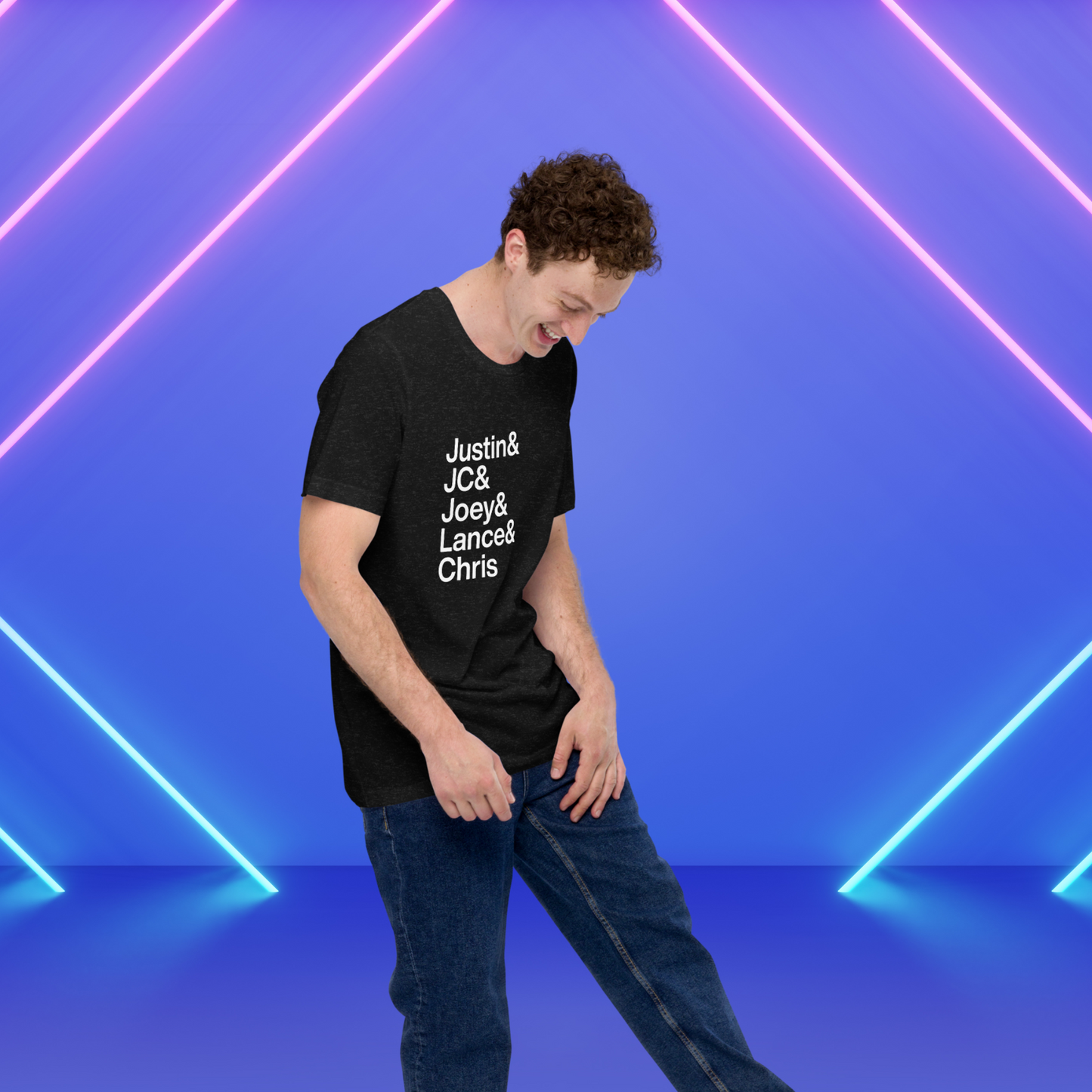 Young man on stage with neon lights wearing black t-shirt with white lettering reading Justin and JC and Joey and Lance and Chris