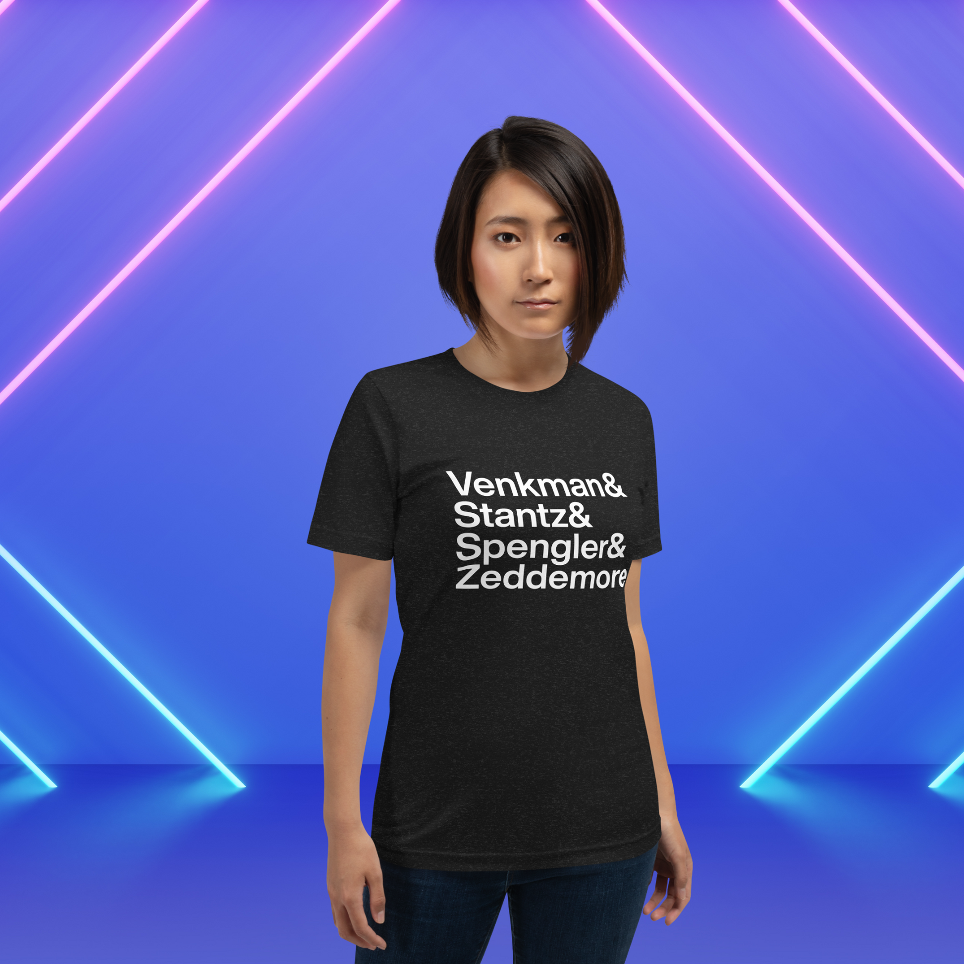 Woman in black t-shirt with white lettering reading Venkman and Stantz and Spengler and Zeddemore in front of neon lights