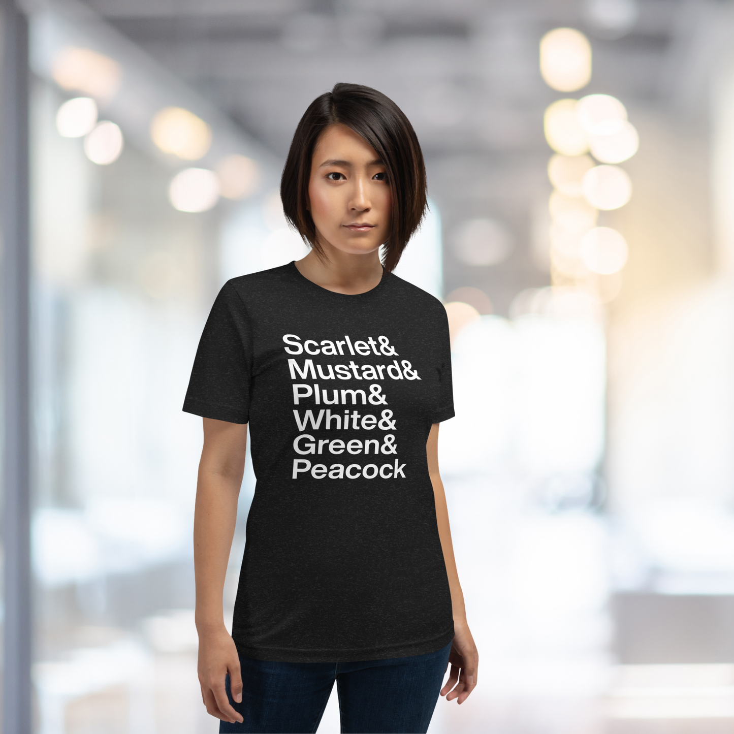 Young woman in hallway wearing a black t-shirt with white lettering depicting the characters from Clue