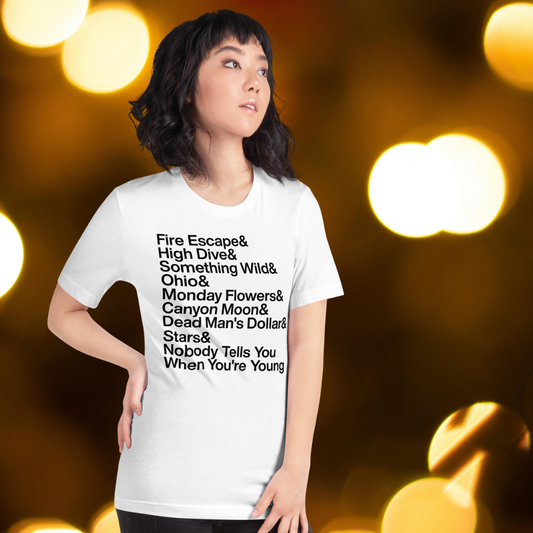 Person wearing a white t-shirt with text against a blurred bokeh background