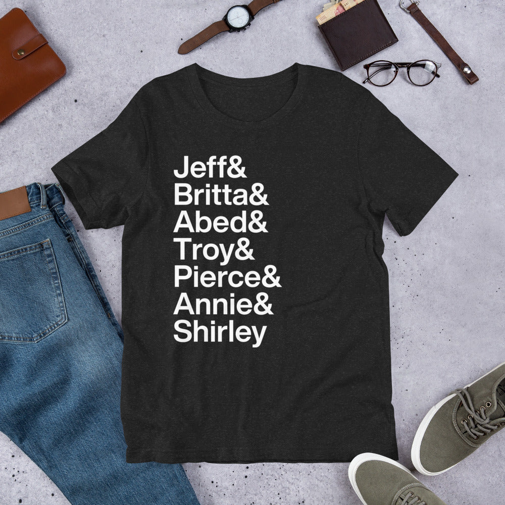 black t-shirt with white lettering reading Jeff and Britta and Abed and Troy and Pierce and Annie and Shirley on the ground amidst other apparel