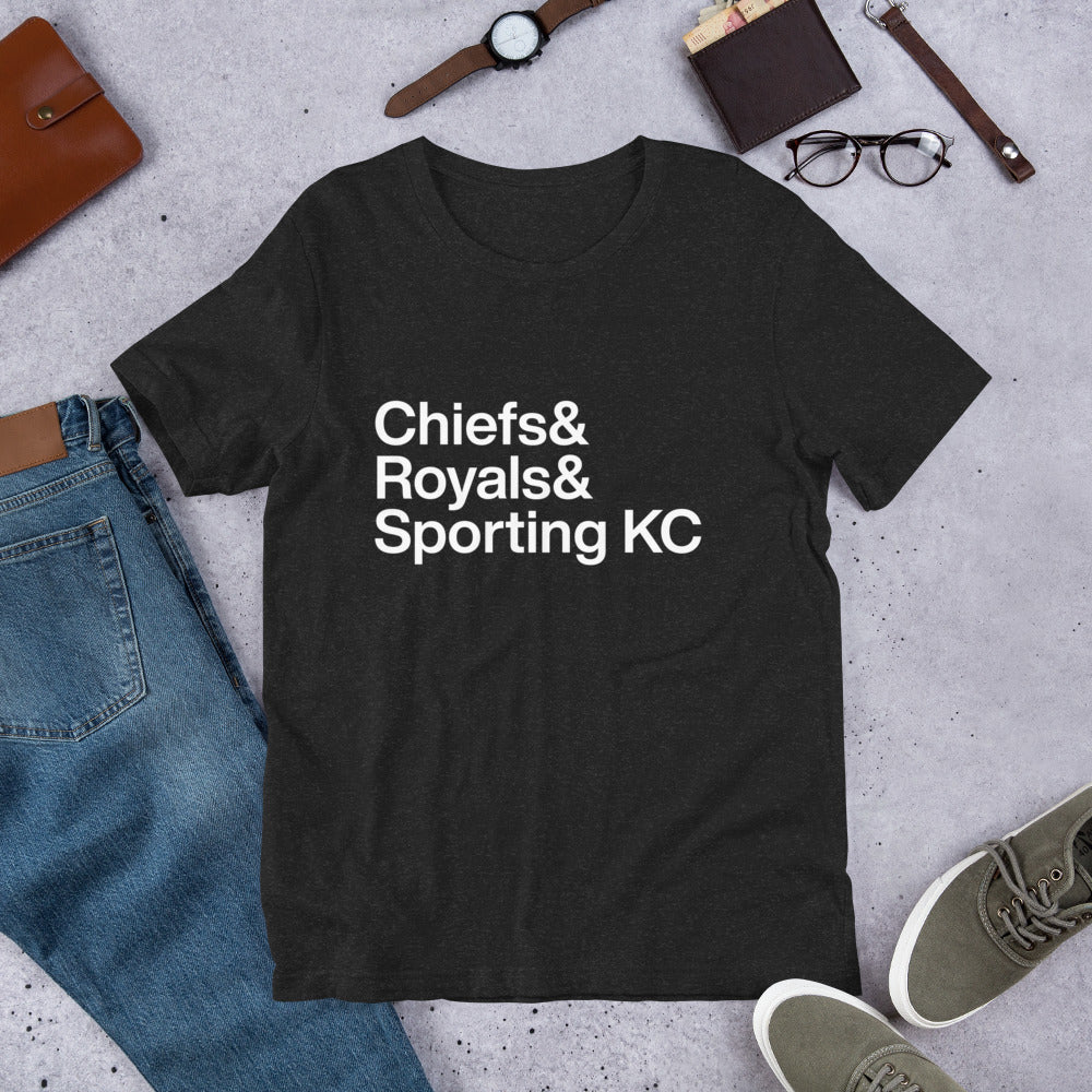 black t-shirt with white lettering reading Chiefs and Royals and Sporting KC on the ground with other apparel