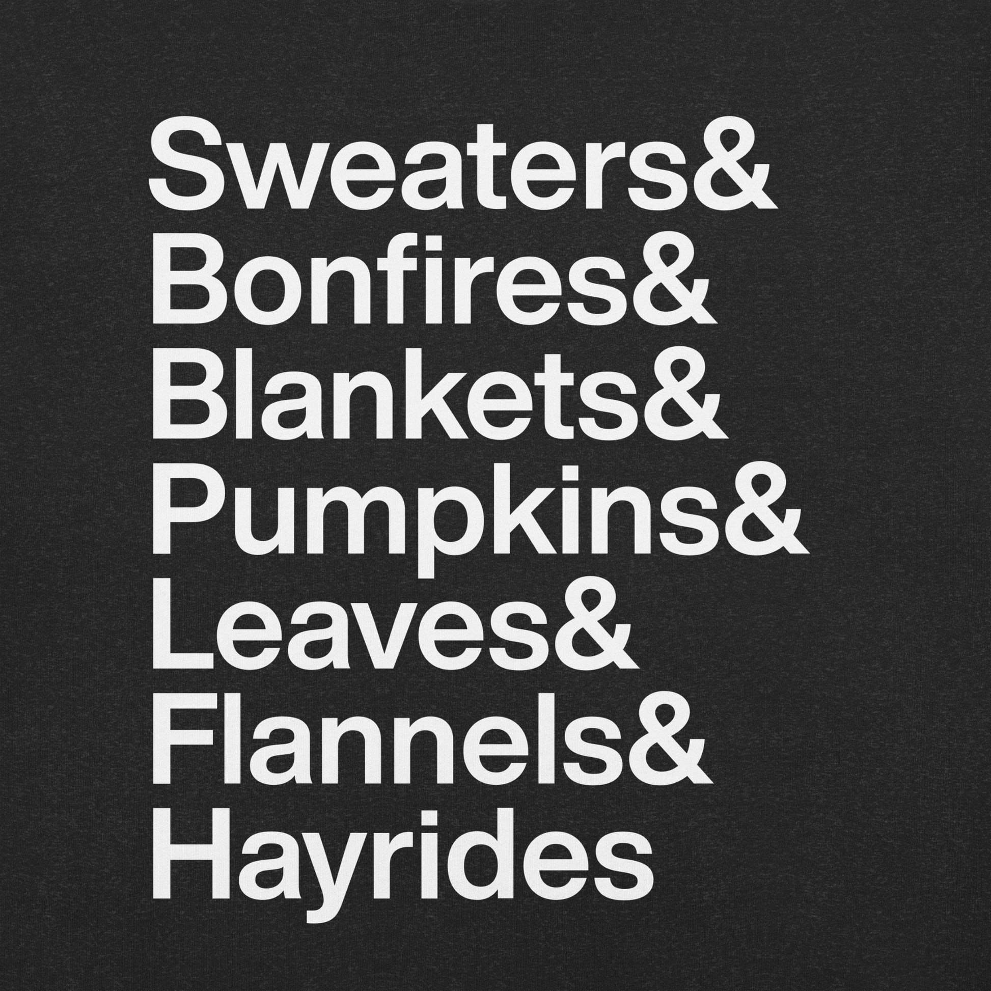 Close up of black t-shirt with white text reading "Sweaters and Bonfires and Blankets and Pumpkins and Leaves and Flannels and Hayrides"