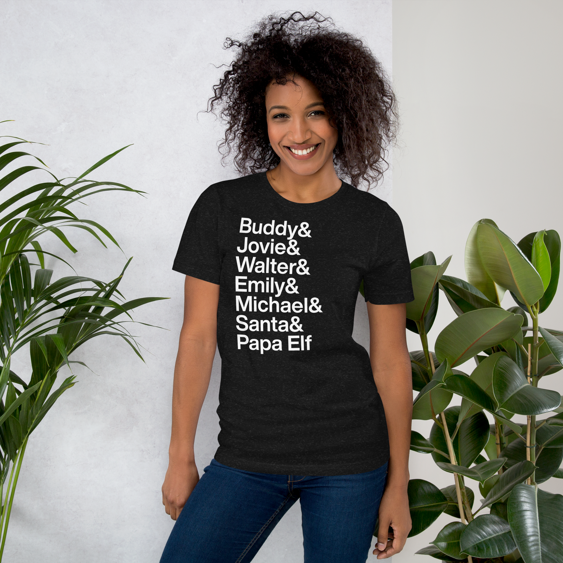 Young woman in black t-shirt with white text reading Buddy and Jovie and Walter and Emily and Michel and Santa and Papa Elf