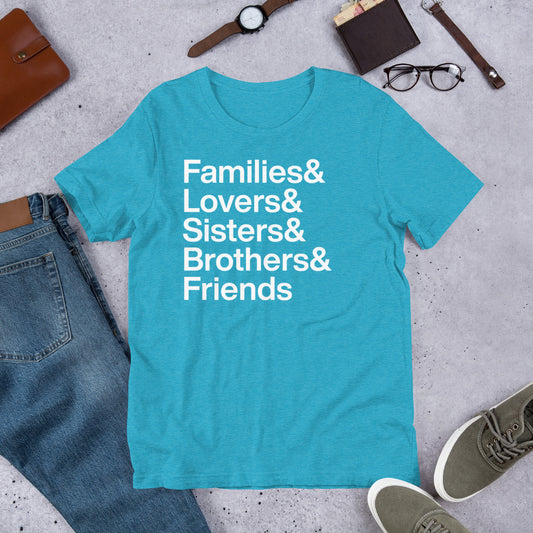 Blue t-shirt with text 'Families & Lovers & Sisters & Brothers & Friends' on a concrete surface with jeans, shoes, and accessories.